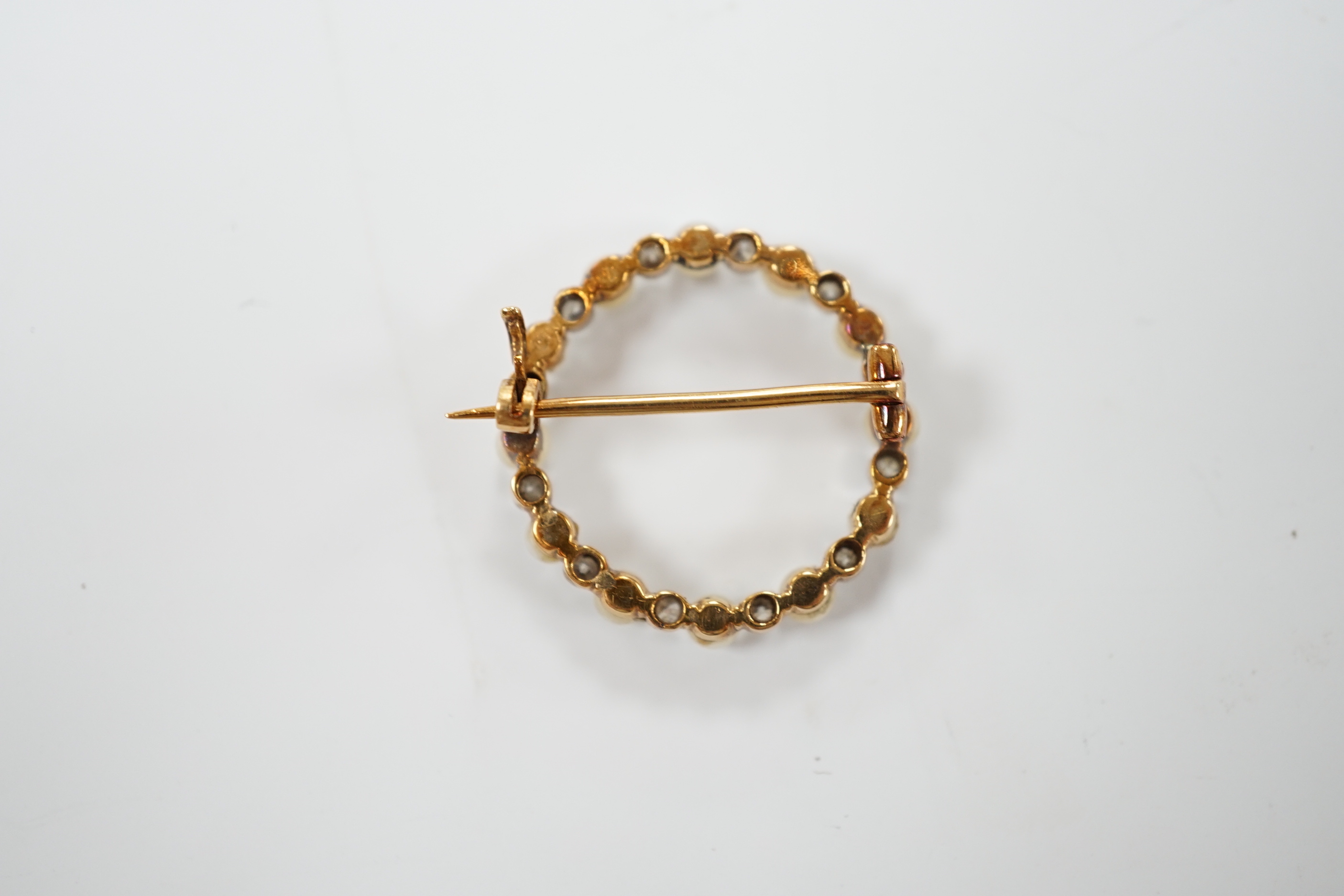 An Edwardian yellow metal, seed pearl and diamond chip set circular open work brooch, 22mm, gross weight 4 grams.
